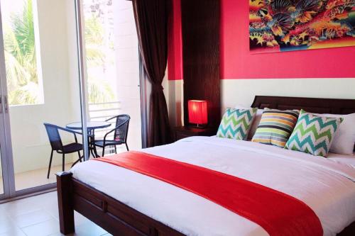 a bedroom with a bed and a table with chairs at OK Phuket in Kata Beach