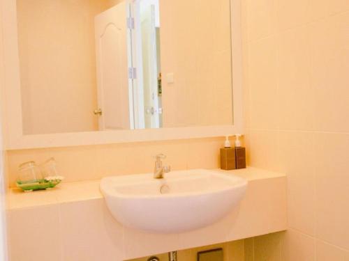 a bathroom with a white sink and a mirror at OK Phuket in Kata Beach