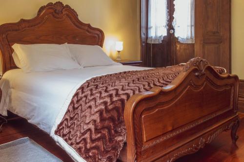 a large bed with a wooden frame in a bedroom at 57 in Porto