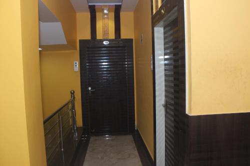 a hallway with a black door in a room at Hotel Kwality Inn in Satna