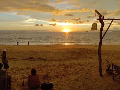 a group of people sitting on a beach at sunset at Sleep Whale Lanta in Ko Lanta