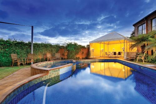 a swimming pool in a backyard with a tent at Best Western Plus Buckingham International in Moorabbin