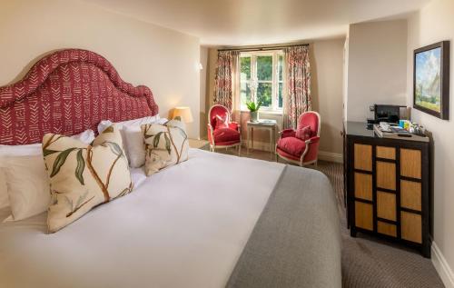 a bedroom with a large bed with a red headboard at Linthwaite House Hotel in Bowness-on-Windermere