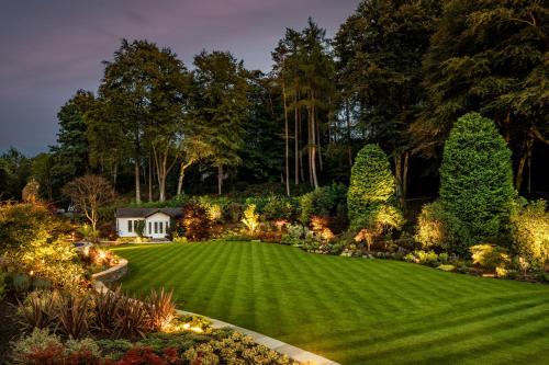 a garden with a green lawn at night at Linthwaite House Hotel in Bowness-on-Windermere