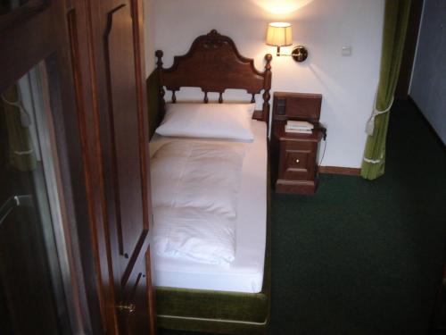 a small bed in a small room next to a door at Regerhof in Germering