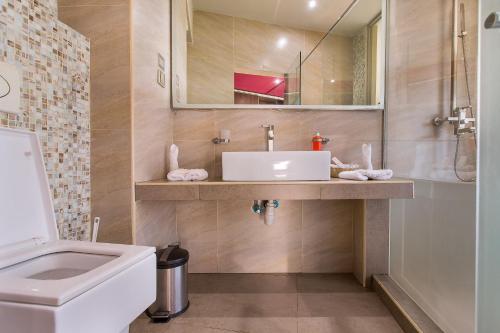 a bathroom with a sink and a toilet and a mirror at Bliss Resort in Nyali