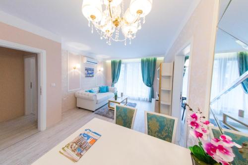 uma sala de estar com uma mesa e um lustre em Harmony Suites - Monte Carlo em Sunny Beach