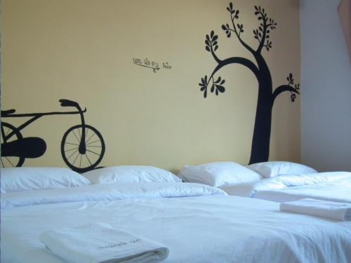 a bedroom with two beds with a tree on the wall at Norn Nab Dao Rimkhong in Chiang Khan