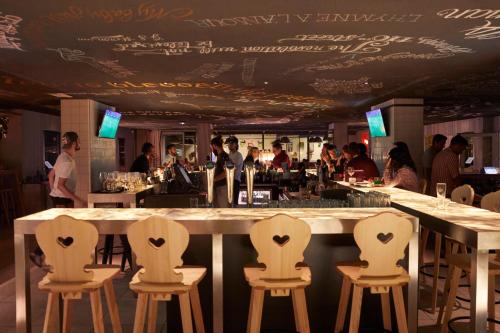 a bar with white chairs in a restaurant at Mama Shelter Marseille in Marseille