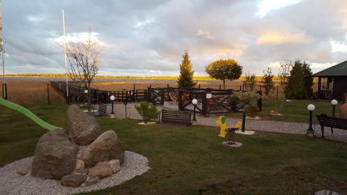 a park with a playground with rocks in the grass at Avila Park & SPA in Dziwnówek