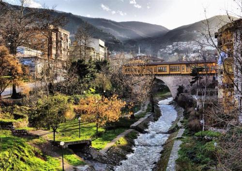 ein Zug auf einer Brücke über einen Fluss in der Unterkunft Kule Hotel in Bursa