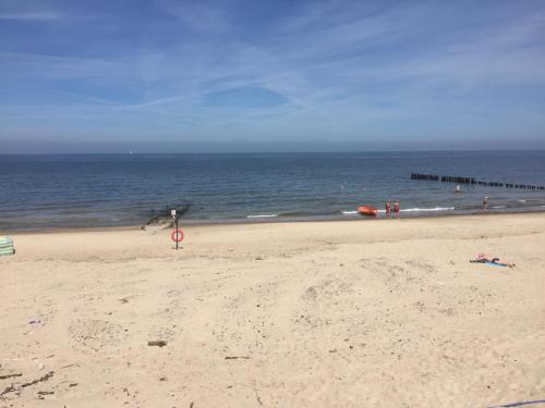 a person is flying a kite on the beach at Avila Park & SPA in Dziwnówek