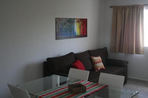 sala de estar con sofá y mesa de cristal en DEPARTAMENTO AZAHARES EN TANDIL en Tandil