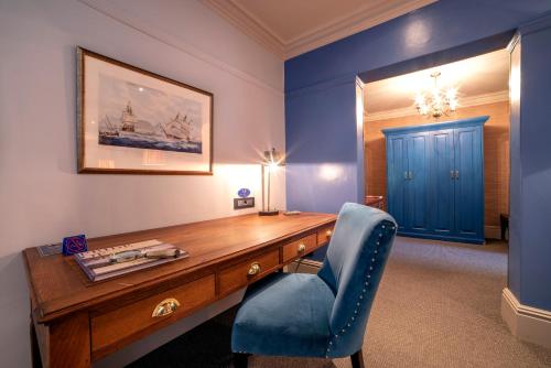 a blue office with a desk and a blue chair at La Fontaine Boutique Hotel by The Oyster Collection in Franschhoek