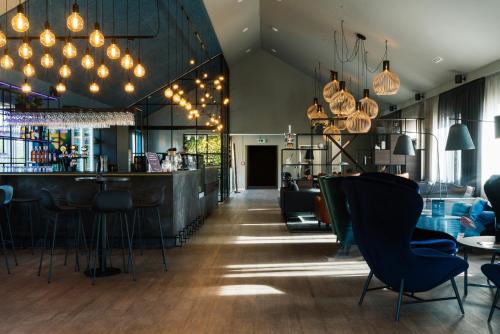 eine Bar in einem Restaurant mit Stühlen und Lichtern in der Unterkunft Copenhagen Go Hotel in Kopenhagen