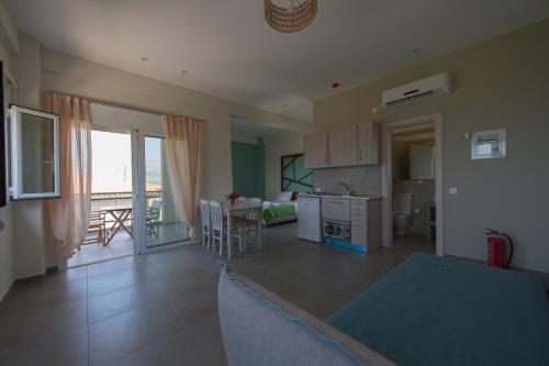 a kitchen and living room with a view of a balcony at Thesmos Village in Mýtikas