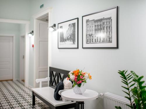 a living room with a bench with a vase of flowers at Art Deco Central Rooms in Lviv