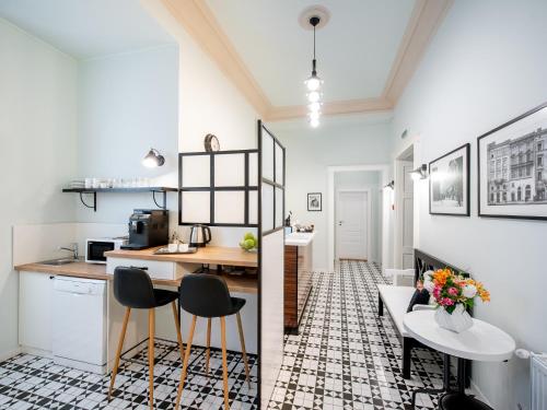 eine Küche und ein Wohnzimmer mit einem Tisch und Stühlen in der Unterkunft Art Deco Central Rooms in Lwiw