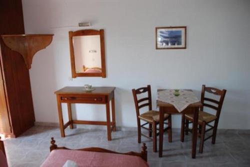 a dining room with a table and chairs and a mirror at Romantza in Skala