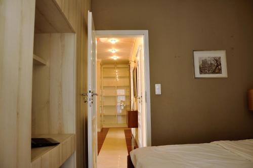 ein Schlafzimmer mit einem Bett und einer Tür, die zu einem Flur führt in der Unterkunft Prudentia Apartments Wilanów in Warschau