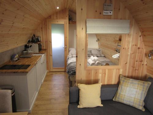 a kitchen and a living room in a log cabin at Harlosh Hideaways - Aurora Pod in Harlosh