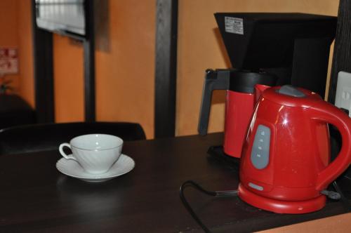 a red tea kettle and a cup on a table at Sakara Gion in Kyoto