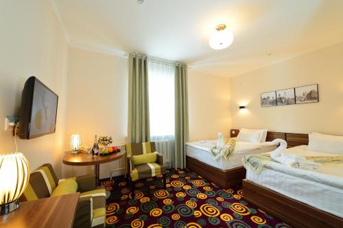 Konfor Hotel Burabay في بوروفوي: غرفة فندقية بسريرين وطاولة
