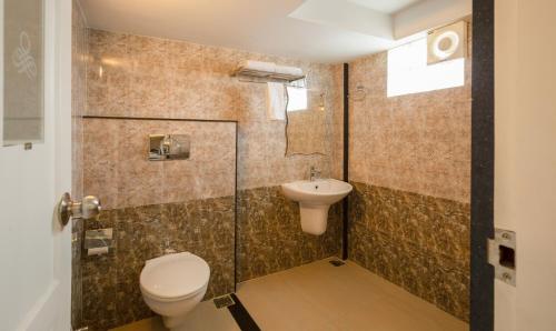 a bathroom with a toilet and a sink at Treebo The Qasr in Cochin