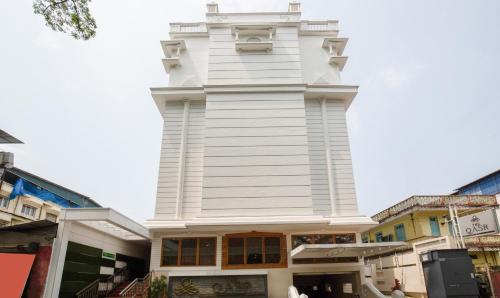 a white building with a tower on top of it at Treebo Trend The Qasr in Cochin