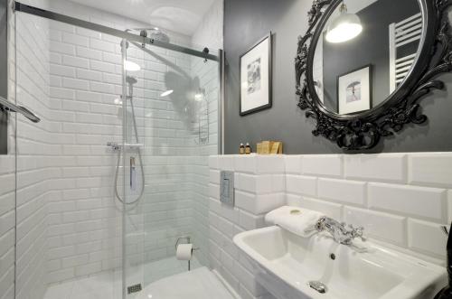 a white bathroom with a sink and a mirror at Happy Stay Old Town Tartaczna Str. 27A in Gdańsk