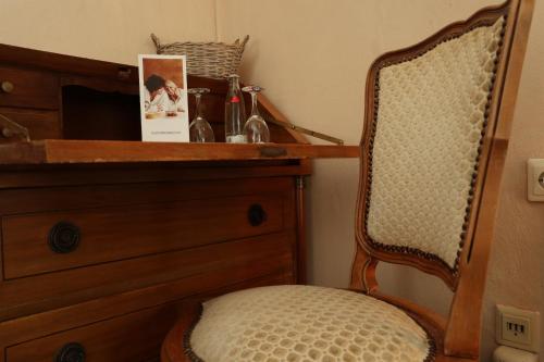 a bedroom with a wooden dresser and a chair at Schwarzwaldhotel Stollen in Gutach im Breisgau