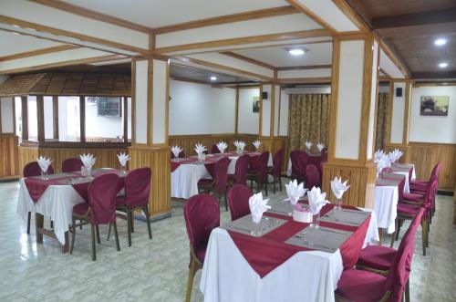 a banquet hall with tables and purple chairs at Yangthang Dzimkha Resort in Pelling