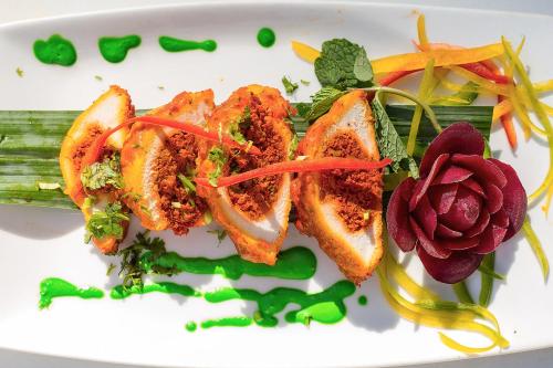 a white plate of food with vegetables on it at Bliss Resort in Nyali