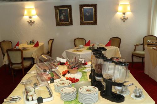 a table in a restaurant with two tables and plates at Schwarzwaldhotel Stollen in Gutach im Breisgau