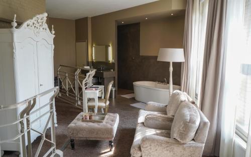 a living room with a tub and a couch and a chair at Huis van Bewaring in Almelo