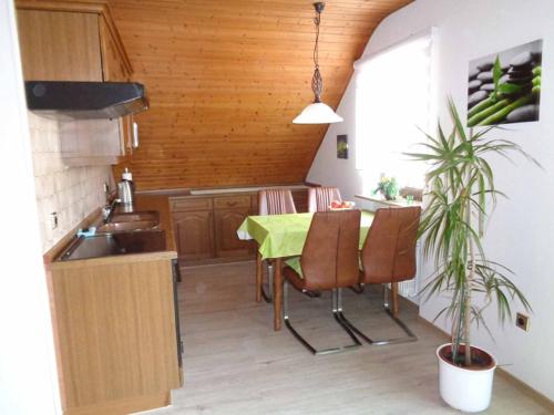 una cocina con una mesa con sillas y una planta en Ferienwohnung Balbach,"Haus Hella", en Lauda-Königshofen