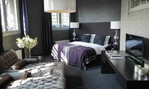 a hotel room with a bed and a couch at Hotel Huis van Bewaring - Bijzonder boutique hotel in historisch pand in Almelo