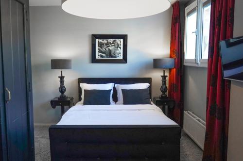 a bedroom with a large bed and a chandelier at Hotel Huis van Bewaring - Bijzonder boutique hotel in historisch pand in Almelo
