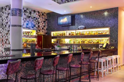 a bar with red chairs in a restaurant at Bliss Resort in Nyali