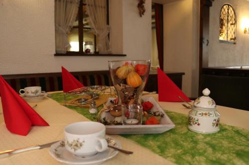 a table with a plate of food and a cup on it at Schwarzwaldhotel Stollen in Gutach im Breisgau