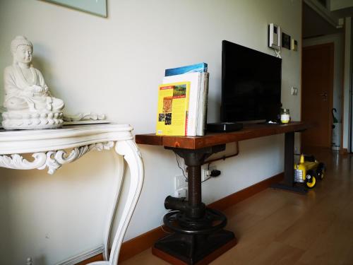 um quarto com uma mesa com uma televisão e uma estátua em Poesia y Vino em Lardero