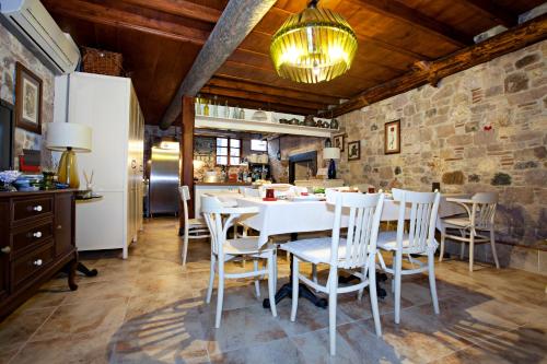 una sala da pranzo con tavolo e sedie bianchi di Macaron Konagi a Ayvalık