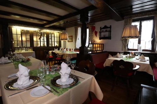 a restaurant with two tables with white tableclothsurrency sidx sidx sidx sidx sidx at Schwarzwaldhotel Stollen in Gutach im Breisgau