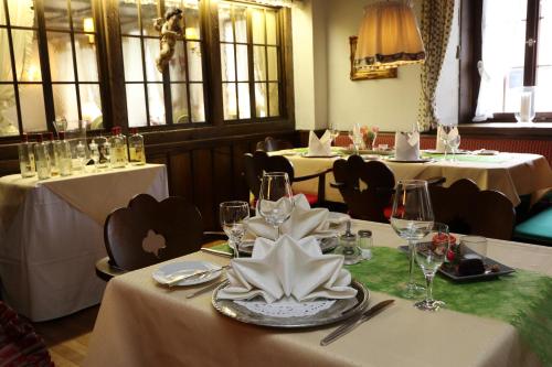 a dining room with two tables with white tableclothsurrencyangering at Schwarzwaldhotel Stollen in Gutach im Breisgau