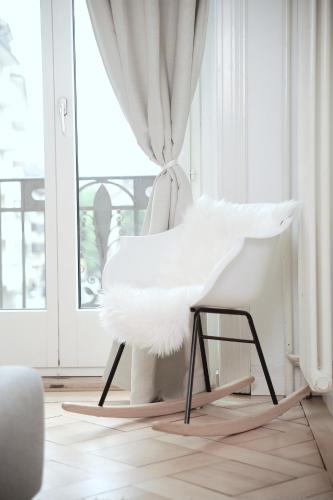 a white chair in a room with a window at Central Bright & Cozy Apartments in Luzern