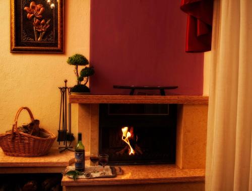 a fireplace in a living room with a fire in it at Achillion Palace in Kalambaki