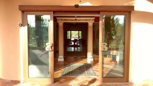 un ingresso a una casa con porta a vetri di Antica Fornace Relais by La Principina a Principina Terra