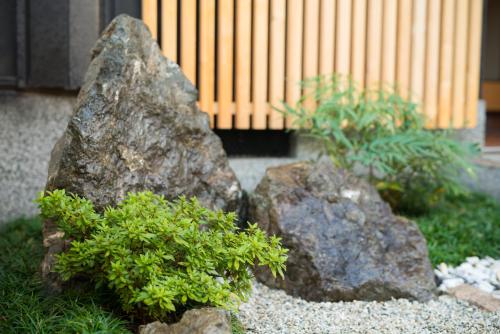 a couple of rocks with plants in a garden at Kujo Ume May In Higashikujo in Kyoto