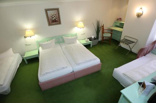 a hotel room with two beds and a table at Schwarzwaldhotel Stollen in Gutach im Breisgau