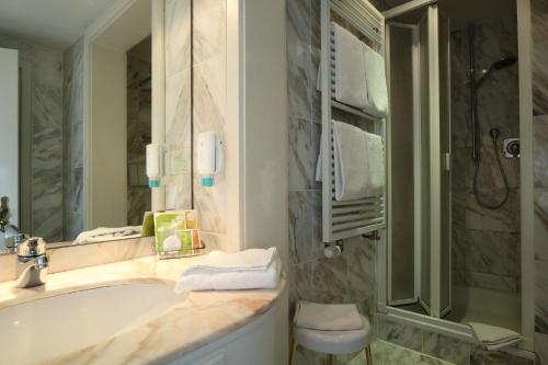 a bathroom with a tub and a sink and a shower at Schwarzwaldhotel Stollen in Gutach im Breisgau